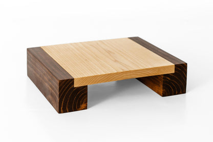 Close-up image of a Poplar plant stand on a wooden bridge. The stand's stained legs and hard-wax oil finish reveal the distinct wood grain pattern.