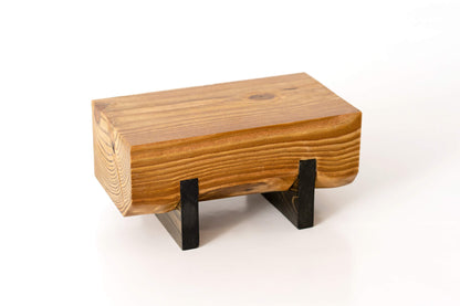 Close-up image of a Pine plant stand showcasing its rich wood grain. The stand, stained and treated with hard-wax oil, houses a small succulent plant.